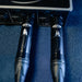 Two Cloudlifter guitar cables plugged into an audio interface on a blue surface.