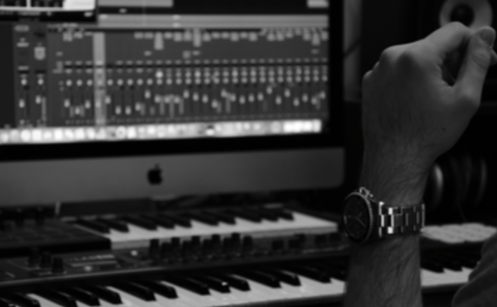 Music producer using audio interface and MIDI keyboard in home studio