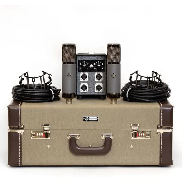 Vintage-style audio equipment set including microphones, cables, and a console on a beige suitcase.